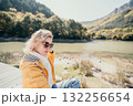 Young Woman in Yellow Jacket Contemplating the Lake 132256654