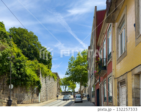 Porto street lined with colorful historic buildings. Cobblestone road and tram tracks curve through Porto street lined with colorful historic buildings. Cobblestone road and tram tracks curve through 132257333