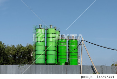 Silos towers, industrial landscape. Concrete and metal vertical towers store raw cement material at 132257334