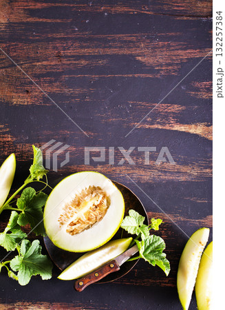 Wooden board with ripe cut melons Wooden board with ripe cut melons 132257384