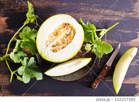 Wooden board with ripe cut melons Wooden board with ripe cut melons 132257385