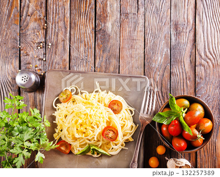 Delicious spaghetti with tomatoes on plate on table close-up 132257389