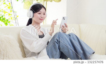 ワイヤレスヘッドフォンで音楽を聞くアジア人女性 132257476