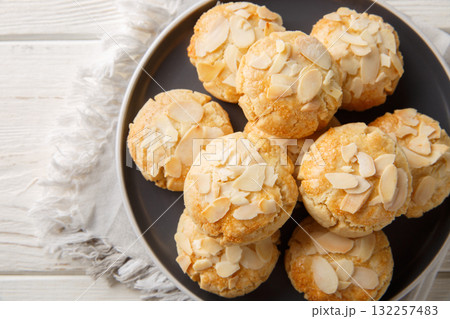 Homemade cracked almond flake cookies close-up in a plate. Horizontal top view Homemade cracked almond flake cookies close-up in a plate. Horizontal top view 132257483
