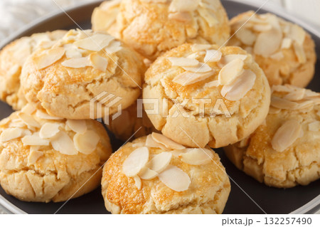 Crispy shortbread cookies with almond flakes close-up in a plate. Horizontal Crispy shortbread cookies with almond flakes close-up in a plate. Horizontal 132257490