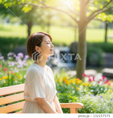 公園のベンチにリラックスして座る若い日本人女性 公園のベンチにリラックスして座る若い日本人女性 132257575