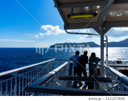 伊豆七島を結ぶ爽やかな船旅の景色 煌めく海と新島を眺める乗客 伊豆七島を結ぶ爽やかな船旅の景色 煌めく海と新島を眺める乗客 132257606