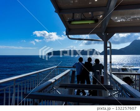 伊豆七島を結ぶ爽やかな船旅の景色 煌めく海と新島を眺める乗客 伊豆七島を結ぶ爽やかな船旅の景色 煌めく海と新島を眺める乗客 132257607