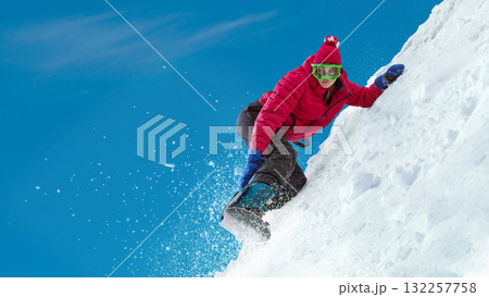 Snowboarder carving snow on slope with snow spray and vivid blue sky background. Handmade collage Snowboarder carving snow on slope with snow spray and vivid blue sky background. Handmade collage 132257758