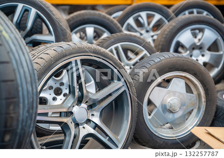 Different car wheels with tires arranged in a row inside an auto workshop. Seasonal tire replacement and service in preparation for winter in Czech Republic. 132257787