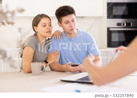 An insurance agent tells young couple the terms of property and life insurance 132257840