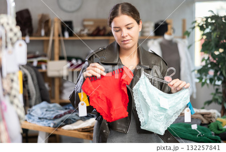 Young woman chooses panties in clothing store 132257841