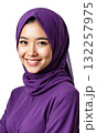 Woman Hijab Purple. A young woman wearing a purple hijab and a matching modest top smiles gently and warmly at 132257975