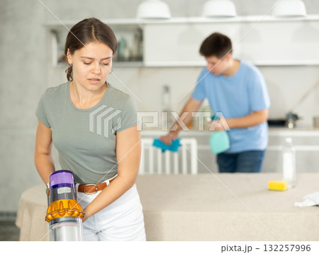 Positive girl and her husband are cleaning kitchen Positive girl and her husband are cleaning kitchen 132257996