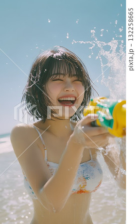 海辺でウォーターガンを打つ水着女性 海辺でウォーターガンを打つ水着女性 132258665