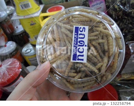 Hand Holding a Container of Fried Insects at a Market Stall for Sale Hand Holding a Container of Fried Insects at a Market Stall for Sale 132258794