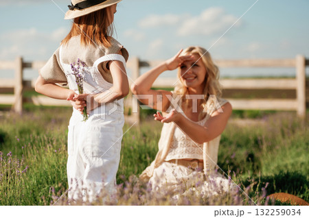 Present for woman, little flowers. Beautiful mother with her daughter on the farm 132259034