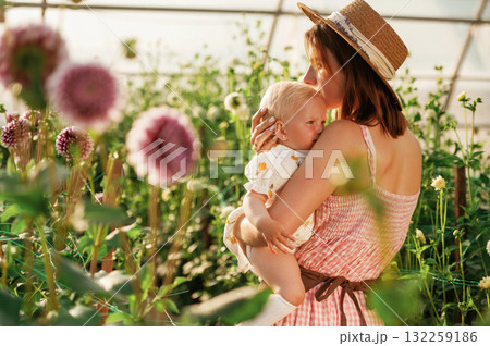 Little cute baby. Mother and daughter are in the greenhouse 132259186