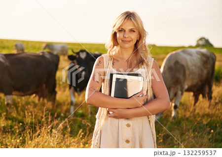 Digital tablet in hands and cows that are behind. Young woman is on the farm Digital tablet in hands and cows that are behind. Young woman is on the farm 132259537