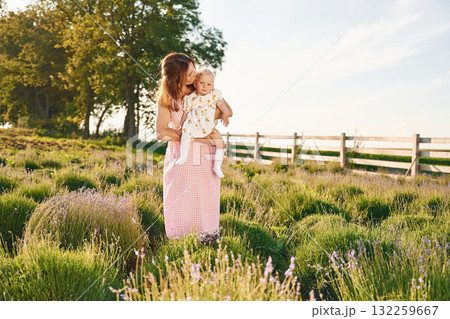 Holding baby in hands. Beautiful mother with her daughter on the farm 132259667