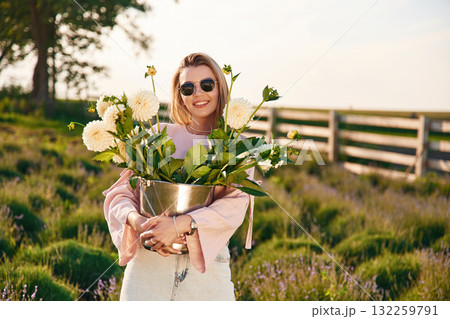 In sunglasses and with flowers. Young woman is on the farm 132259791