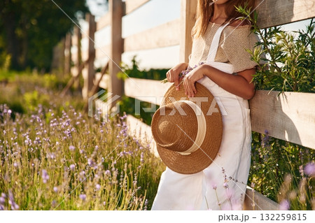 Leaning on the wooden fence. Cute little girl is on the farm 132259815