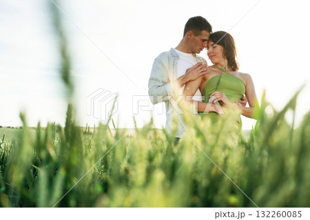 Standing and enjoying nature and each other. Lovely couple are on the agricultural field together Standing and enjoying nature and each other. Lovely couple are on the agricultural field together 132260085