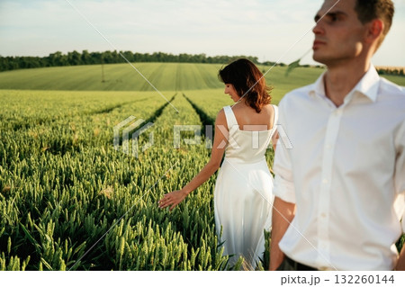 Wedding clothes. Lovely couple are on the agricultural field together Wedding clothes. Lovely couple are on the agricultural field together 132260144