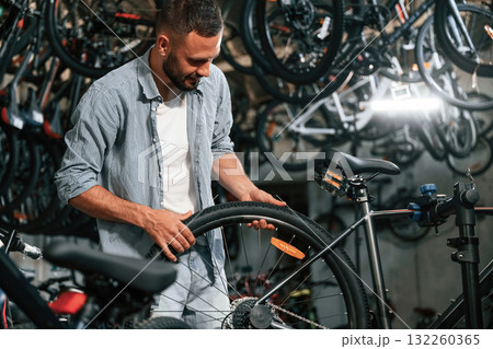 Working in the store. Repair man in bicycle shop Working in the store. Repair man in bicycle shop 132260365