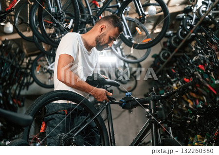Working in the store. Repair man in bicycle shop Working in the store. Repair man in bicycle shop 132260380