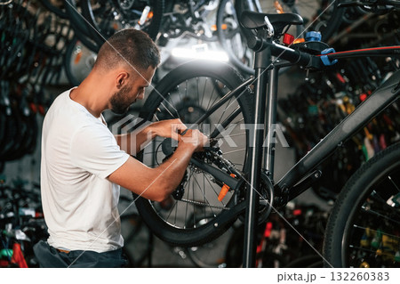 Focused at job. Repair man in bicycle shop, working in store 132260383