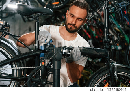 Professional occupation. Repair man in bicycle shop, working in store 132260441
