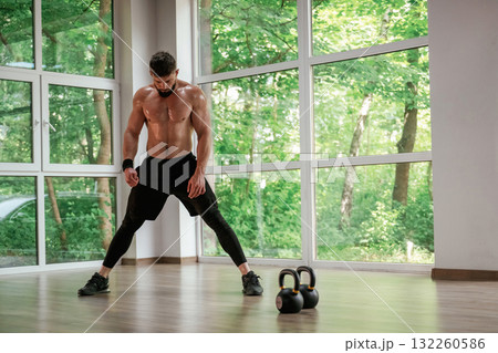 Focused at the exercise. Strong muscular man is working out in the gym 132260586