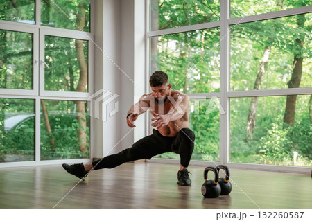 Focused at the exercise. Strong muscular man is working out in the gym Focused at the exercise. Strong muscular man is working out in the gym 132260587