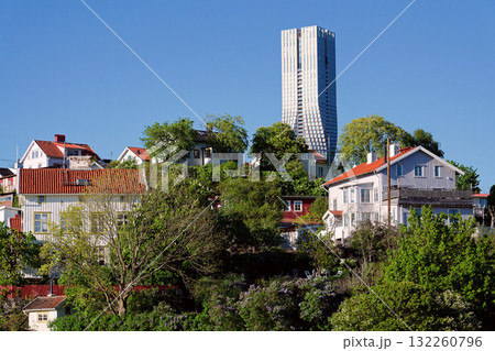 Colony of small wooden historic houses on the Slottsberget mountain with the tallest Scandinavian building Karlatornet skycraper in Lindholmen, Gothenburg, Sweden Colony of small wooden historic houses on the Slottsberget mountain with the tallest Scandinavian building Karlatornet skycraper in Lindholmen, Gothenburg, Sweden 132260796