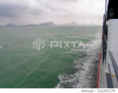 Scenic Ocean View with Distant Islands from a Moving Boat on a Cloudy Day Scenic Ocean View with Distant Islands from a Moving Boat on a Cloudy Day 132261176
