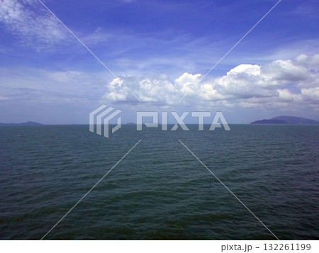 An Expansive Ocean View with Distant Islands Under a Bright Blue Sky with Clouds An Expansive Ocean View with Distant Islands Under a Bright Blue Sky with Clouds 132261199