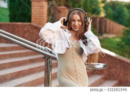 Near the university. Beautiful female student is outdoors 132261349