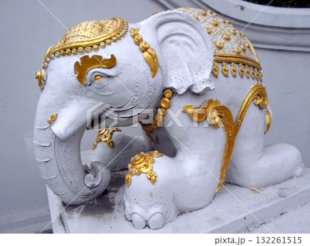 Ornate White Elephant Sculpture with Golden Accents on a Stone Pedestal Ornate White Elephant Sculpture with Golden Accents on a Stone Pedestal 132261515