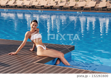 Beautiful woman in bikini is resting by the pool 132261600