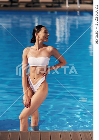 Front view. Beautiful woman in bikini is resting by the pool Front view. Beautiful woman in bikini is resting by the pool 132261621