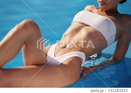 Lying down, close up view. Beautiful woman in bikini is resting by the pool 132261623