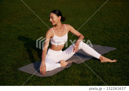 Taking a break. Attractive young fitness woman is on the green grass at daytime Taking a break. Attractive young fitness woman is on the green grass at daytime 132261637