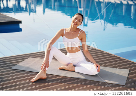 Clear water behind. Fitness woman is near the pool 132261692