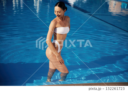 Enjoying the vacation. Beautiful woman in bikini is resting by the pool 132261723