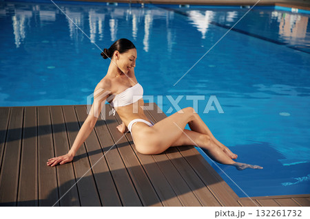 Near the water, rest. Beautiful woman in bikini is resting by the pool 132261732