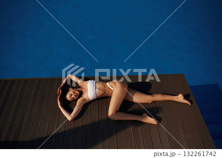 Near the water, rest. Beautiful woman in bikini is resting by the pool 132261742