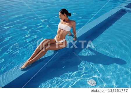 Conception of wellness. Beautiful woman in bikini is resting by the pool Conception of wellness. Beautiful woman in bikini is resting by the pool 132261777