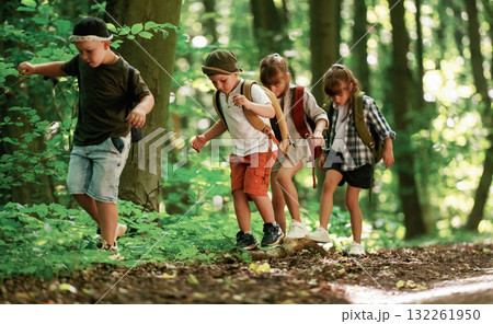 Going on the pathway. Kids in forest at summer daytime together 132261950