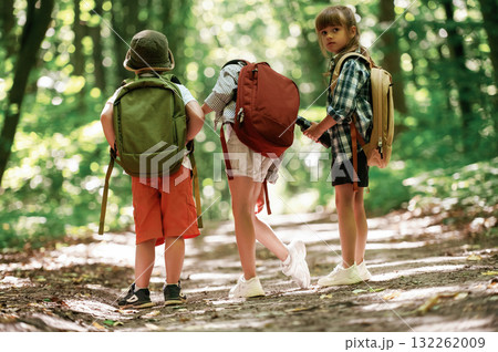 Two girls and a boy. Kids in forest at summer daytime together 132262009